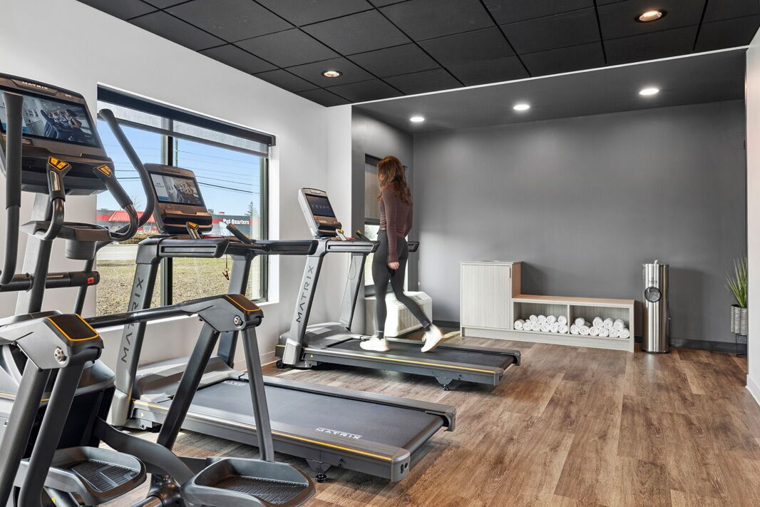 A gym with treadmills, a bench, and a water dispenser.