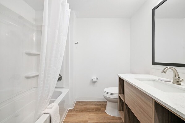 Une salle de bain moderne équipée d’une baignoire, de toilettes et d’un lavabo.