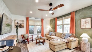 Una sala de estar con sofá, sillón, mesa de centro y una zona de comedor con mesa y sillas.