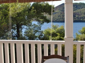 A wooden deck with a view of a lake and hills.