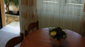 A round dining table with a floral centerpiece. - Apartments Maritimo - Two Bedroom Apartment with Sea View and Terrace (Smokvica)