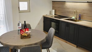 A modern kitchen with a built-in oven, a sink, and a dining area with a table and chairs. - Villa Casa Mia Sabunike A3 (Privlaka)