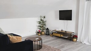 A modern living room with a sofa, a coffee table, a TV, and a console table with decorative items. - Villa Casa Mia Sabunike A3 (Privlaka)