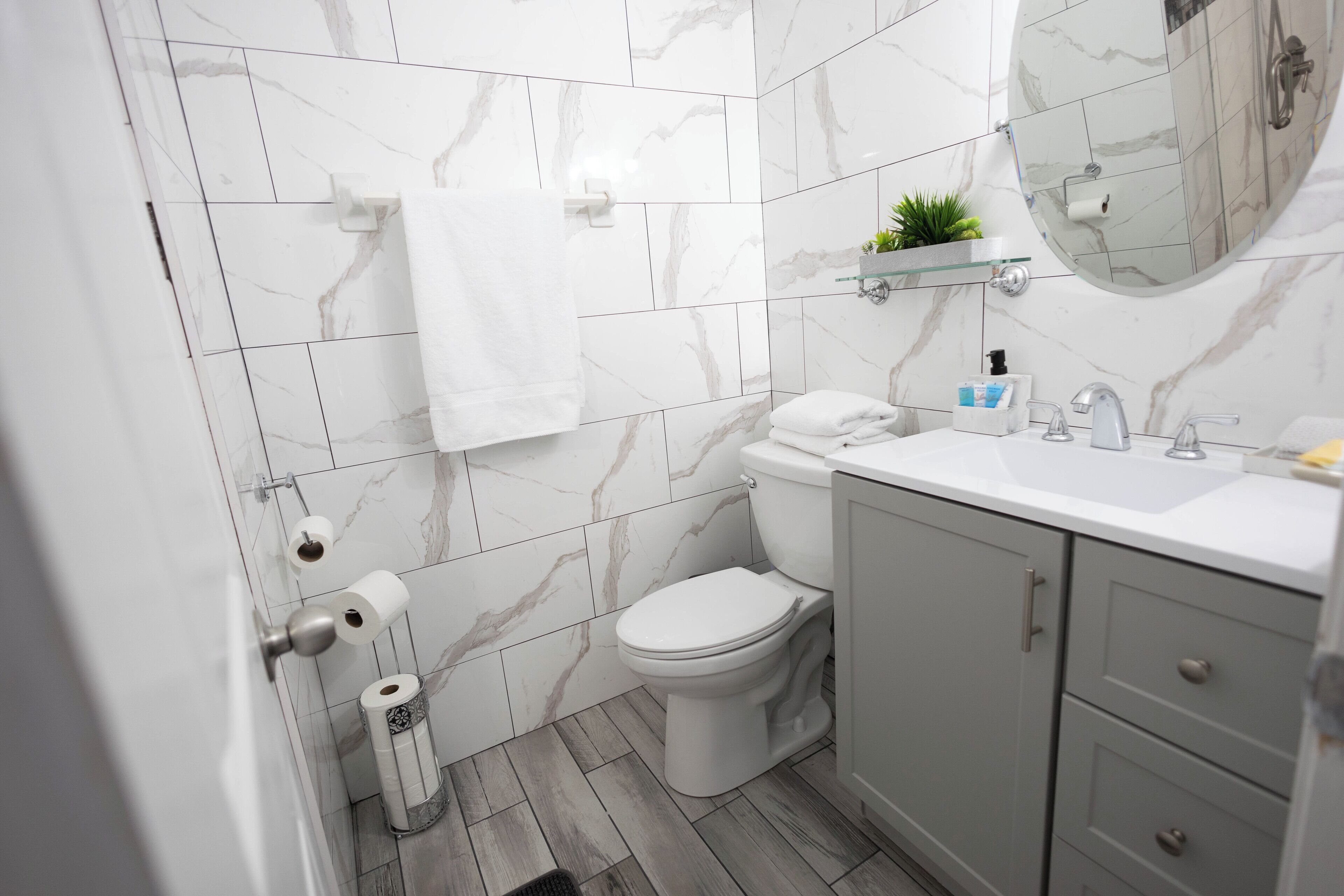 Une salle de bain avec des toilettes, un lavabo et un miroir.
