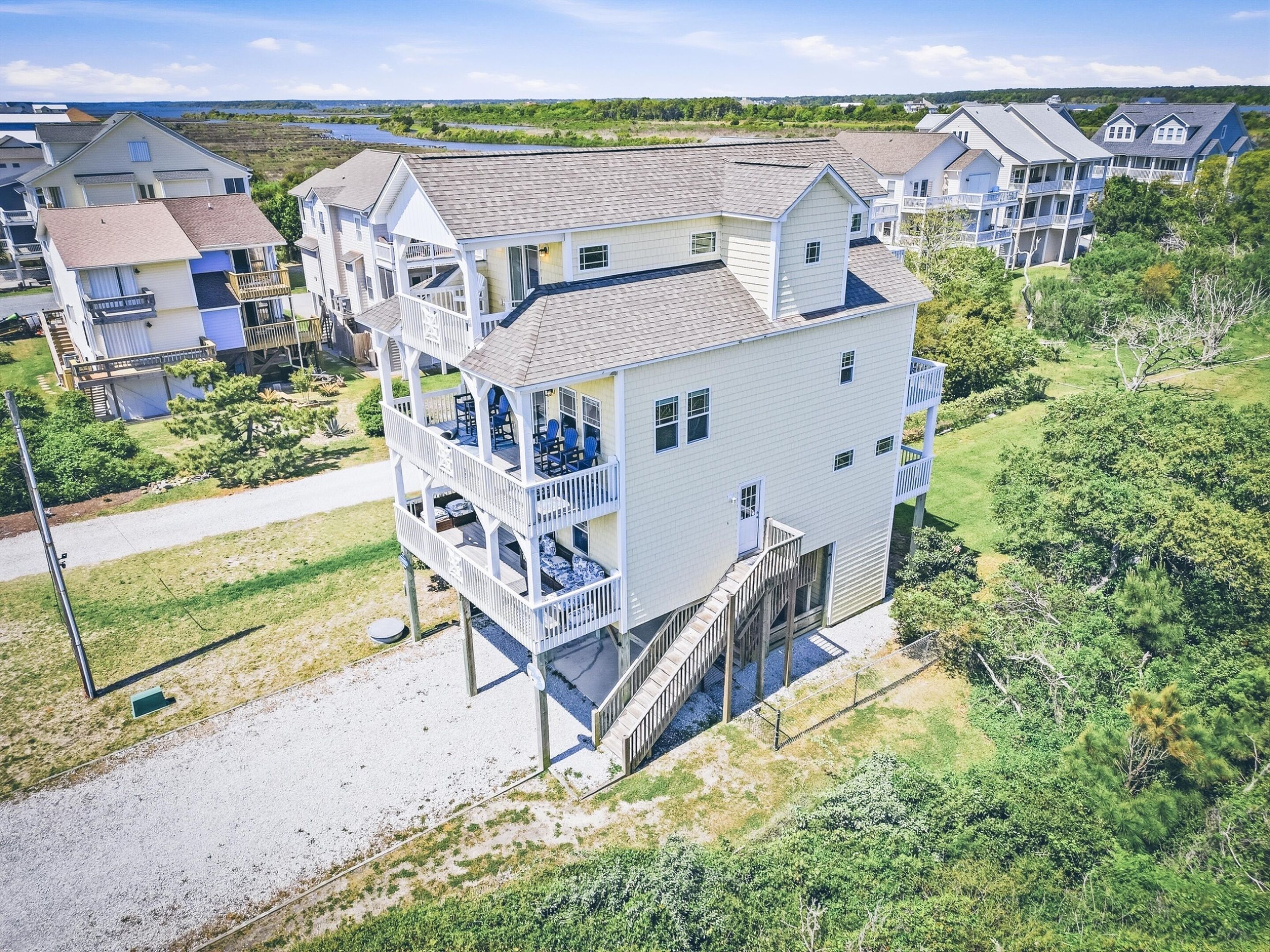A multi-story residential building with a balcony on the second floor, a covered outdoor area, and a view of the surrounding neighborhood.