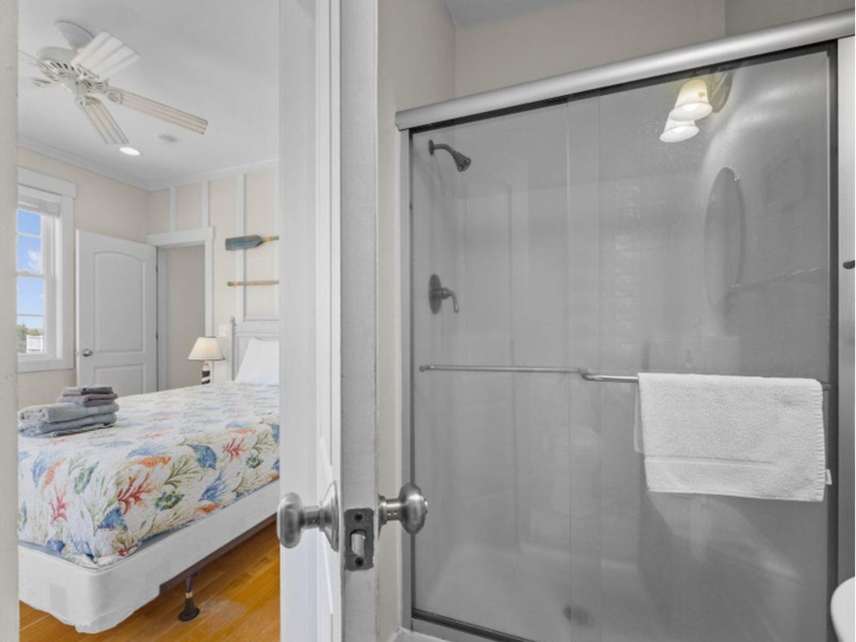 A bedroom with a bed, a bedside table, a lamp, and a window.