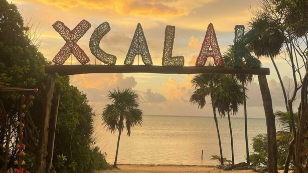 A beach entrance with a sign spelling "XCALAJ" and palm trees. - Sol y Arena Xcalak (Xcalak)