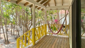 A covered wooden deck with a ceiling fan, surrounded by trees and a hammock. - Sol y Arena Xcalak (Xcalak)