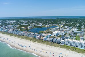 Luchtbeeld van een kustplaatsje met een strand, woongebouwen en een groot hotel.
