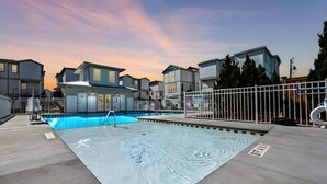A swimming pool with a metal ladder and a white fence. - Sea You On Second by Carolina Retreats (Carolina Beach)