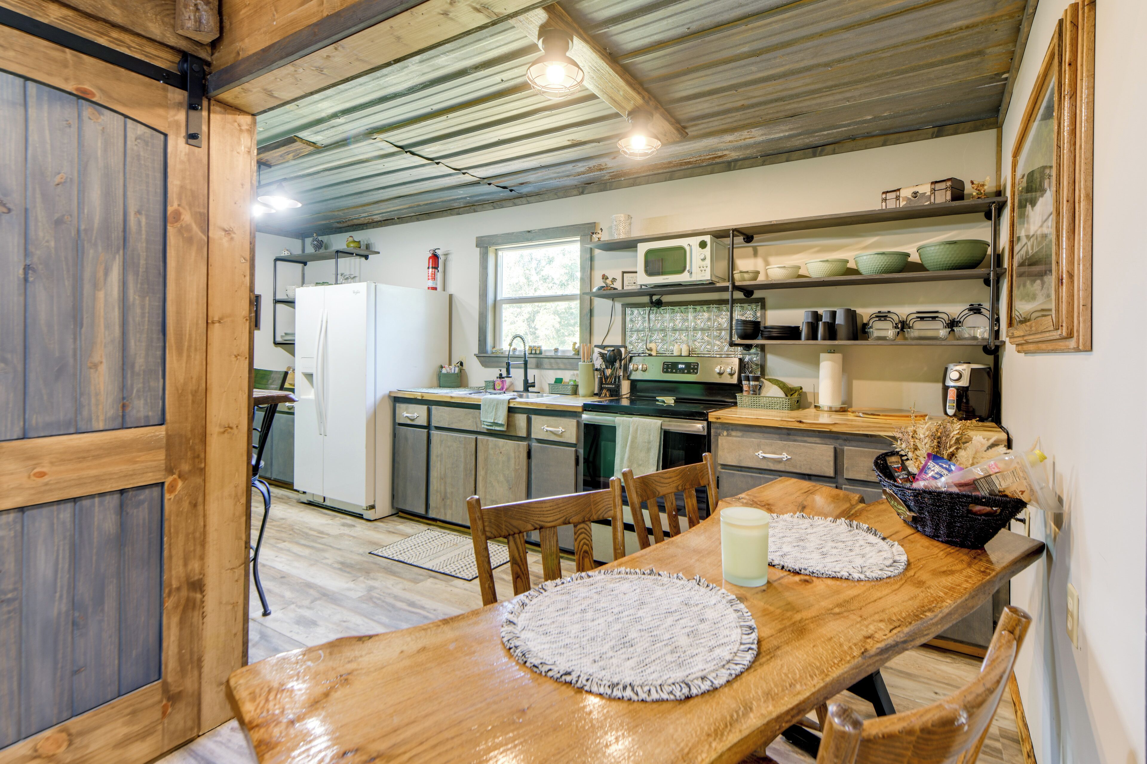 Une cuisine rustique avec des meubles en bois, une table à manger avec des sets de table et une fenêtre donnant sur le jardin.