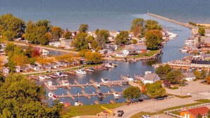 A marina with boats docked, surrounded by residential buildings and trees. - River’s Bend Sanctuary- WALK to Beach & Downtown (Caseville)