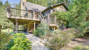 A two-story house with a covered porch and a staircase leading to the upper level.
