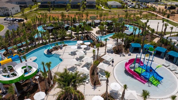 Un resort con varias piscinas, toboganes acuáticos y tumbonas.