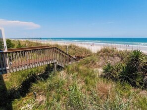 A beach view with a wooden boardwalk leading to the shore. - Pana-Sea-A by Topsail Realty (Holly Ridge)