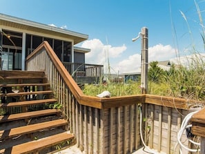 A wooden staircase leading to a deck area with a view of a house and surrounding vegetation. - Pana-Sea-A by Topsail Realty (Holly Ridge)