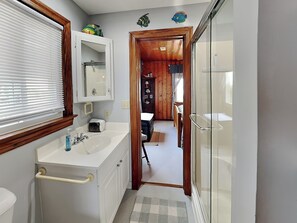 A bathroom with a sink, mirror, and toilet. - Pana-Sea-A by Topsail Realty (Holly Ridge)