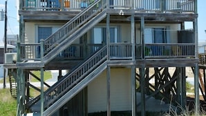 Una casa a due piani in legno con un balcone e una scala.