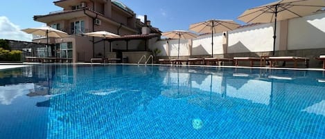 Piscine extérieure en saison, accÚs possible de 8 h à 20 h, parasols