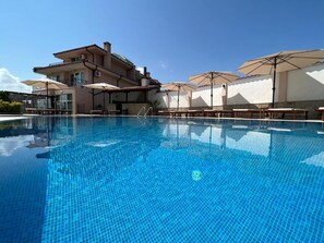 Seasonal outdoor pool, open 8:00 AM to 8:00 PM, pool umbrellas