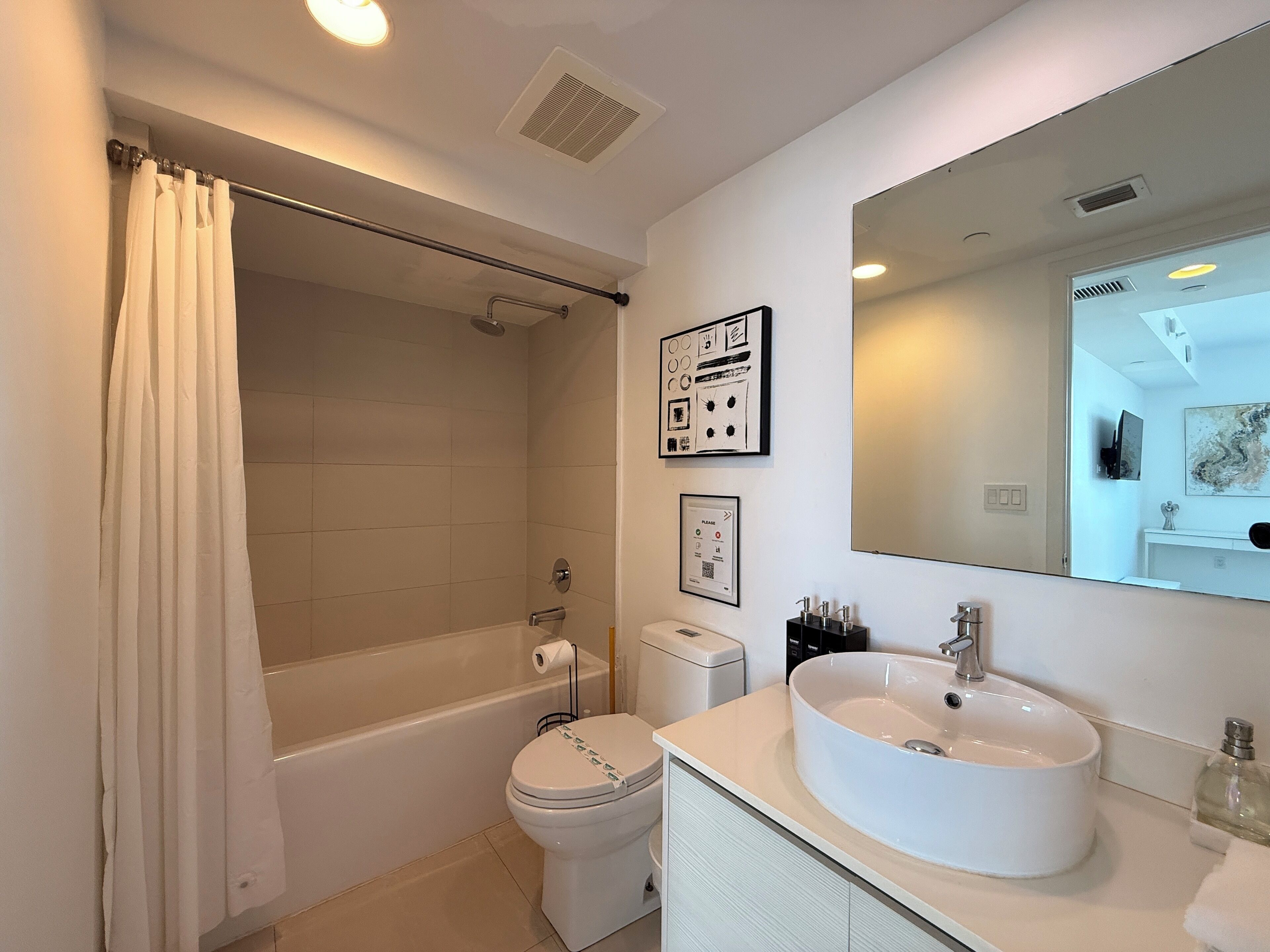 A modern bathroom with a bathtub, toilet, and sink.
