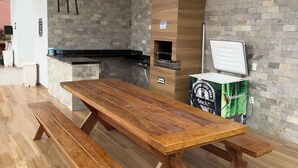 A modern kitchen with a stone backsplash, wooden countertop, and a Heineken refrigerator.