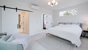 A modern bedroom with a large bed, a small desk, a chair, and a window. - Modern West Seattle Home with View, 3bed, 2.5bath, AC, 2Parking (Seattle)