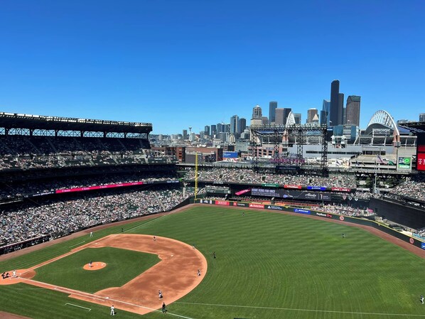 A baseball stadium with multiple levels of seating, a large field, and a city skyline in the background. - Modern West Seattle Home with View, 3bed, 2.5bath, AC, 2Parking (Seattle)