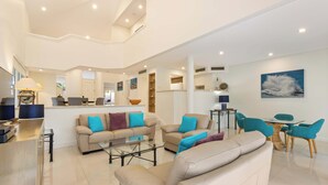 Un vaste espace de vie comprenant une cuisine, un coin repas et une grande fenêtre.
