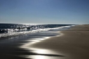 A beach with a clear sky and calm sea.