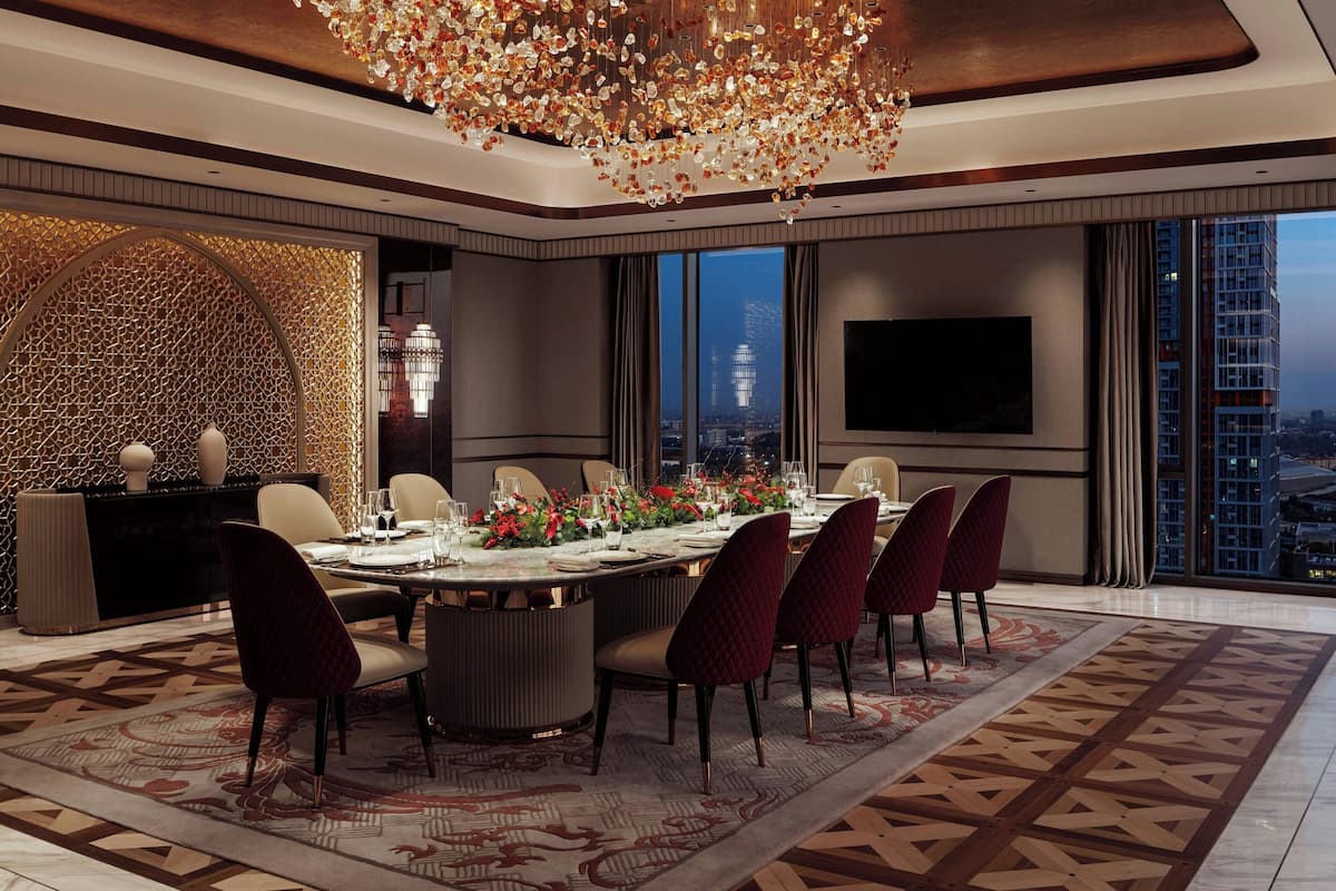 Un comedor moderno con una mesa grande dispuesta para seis personas, un candelabro y vistas a la ciudad.