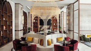 A modern lobby with a curved seating area, a large chandelier, and a marble floor. - JW Marriott Hotel Tashkent (Tashkent)