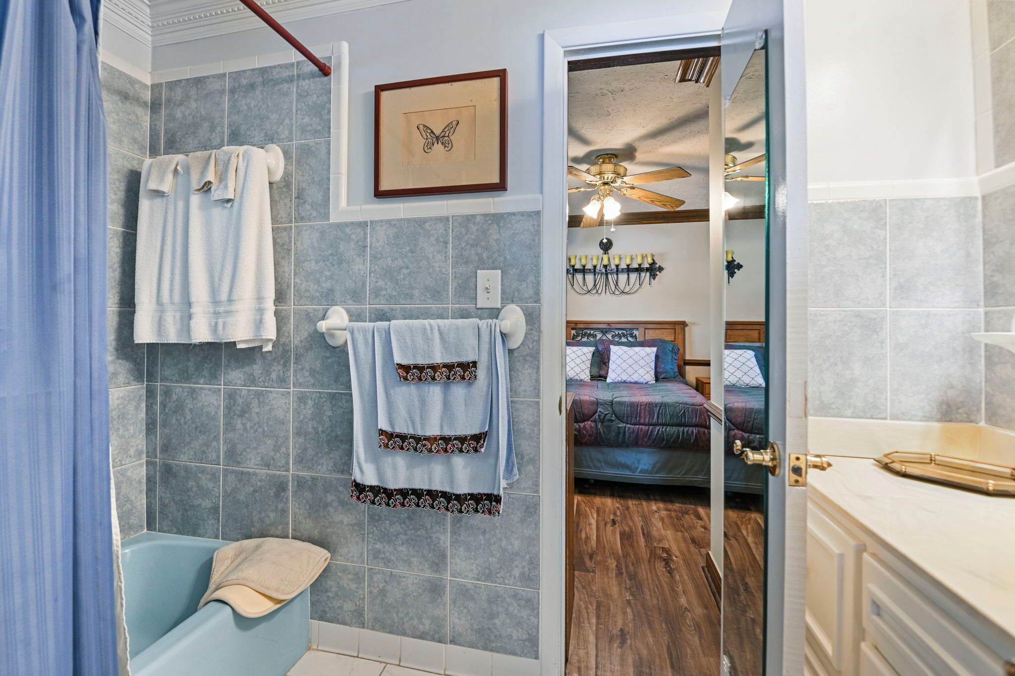 A bathroom with a bathtub, towels, and a shower curtain.