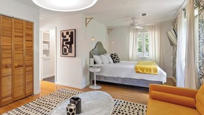 A modern bedroom with a bed, a sofa, a coffee table, and a wardrobe. - The Big Chill – 4BR 2.5BA, Sleeps 10, Auburn Retreat Near Downtown & Campus (Auburn)