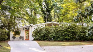 A single-story house with a covered porch, a front door, and a small seating area with two chairs. - The Big Chill – 4BR 2.5BA, Sleeps 10, Auburn Retreat Near Downtown & Campus (Auburn)