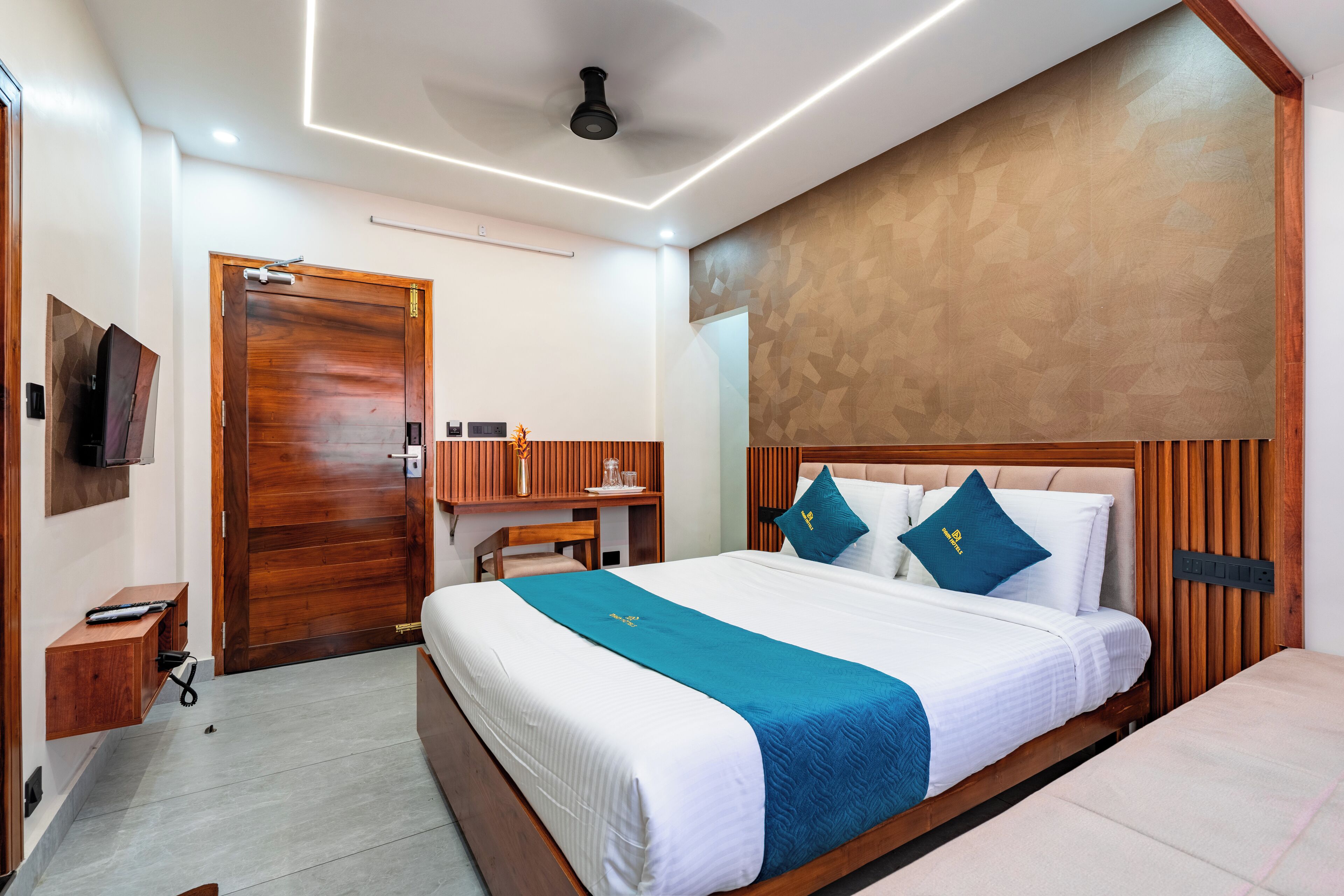 Una habitación de hotel moderna con una cama de madera, un escritorio y una televisión en la pared.