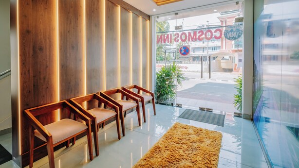 Un área de recepción con paneles de madera, un gran letrero iluminado y vistas a la calle.