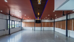 Una habitación amplia y moderna con techo alto, ventanas grandes y un televisor de pantalla plana montado en la pared.