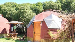 A small wooden cabin with a red roof, a wooden door, and a picnic table in the yard. - DOmos Ocoa (Hijuelas)