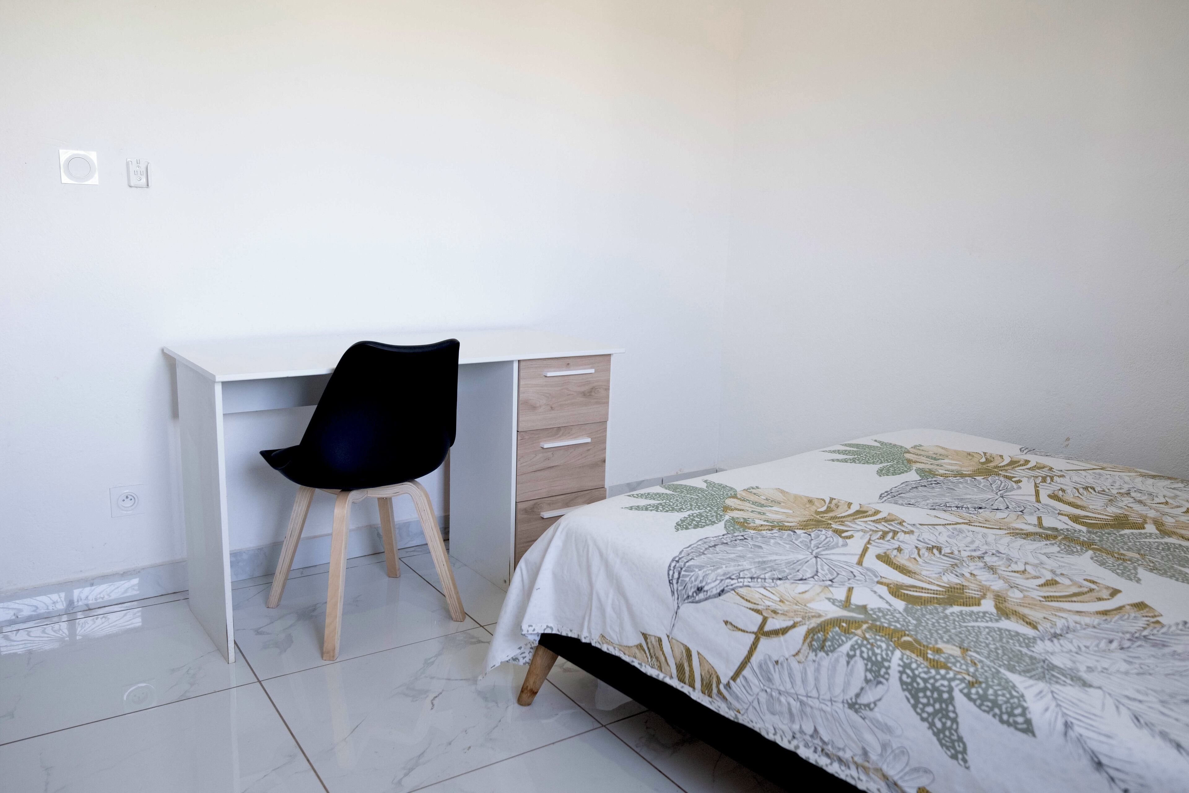 Une chambre à coucher avec un lit, un bureau et une chaise.