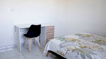 Une chambre à coucher avec un lit, un bureau et une chaise.