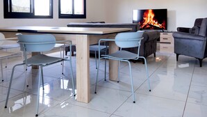 Una sala de estar moderna con chimenea, una mesa de comedor y dos sillas.