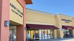 Una fachada con letreros que indican 'Ann Taylor Factory Store' y 'Banana Republic Factory Store'.