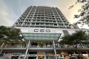 Un hôtel de grande hauteur au design moderne, caractérisé par un grand panneau indiquant « C20 », de nombreux étages et une façade en verre.