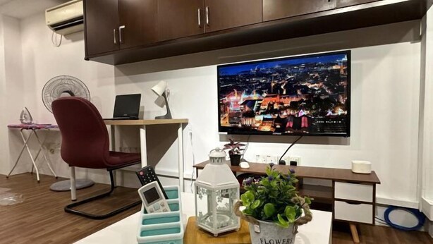 A modern room with a desk, chair, TV, air conditioner, and a potted plant. - The CEO SuiteZ1 By Homey Planet (Bayan Lepas)