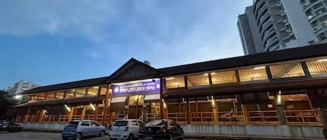 A building with a sign indicating it is a hotel. There are cars parked in front.