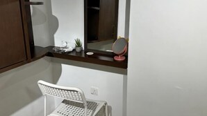 A bathroom with a white chair, a mirror, a small plant, and a towel rack. - The CEO SuiteZ1 By Homey Planet (Bayan Lepas)