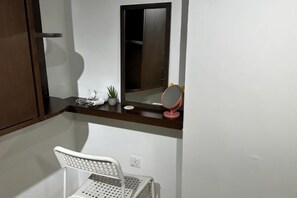 A bathroom with a white chair, a mirror, a small plant, and a towel rack. - The CEO SuiteZ1 By Homey Planet (Bayan Lepas)