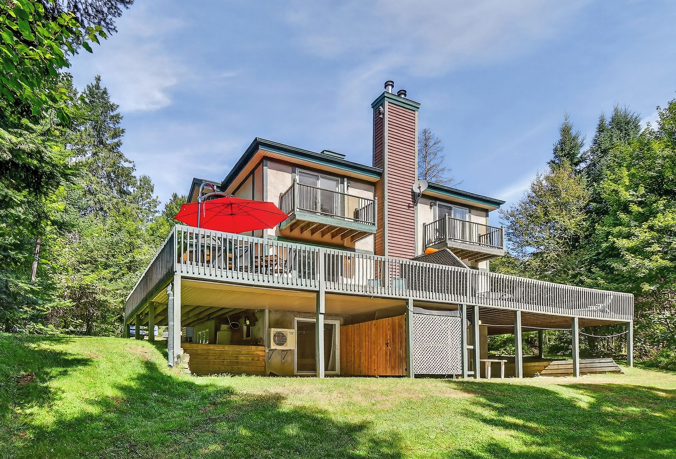 A two-story house with a balcony, a chimney, and a covered outdoor area.