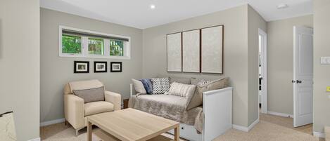 A modern living room with a sofa, a coffee table, and a window with blinds.
